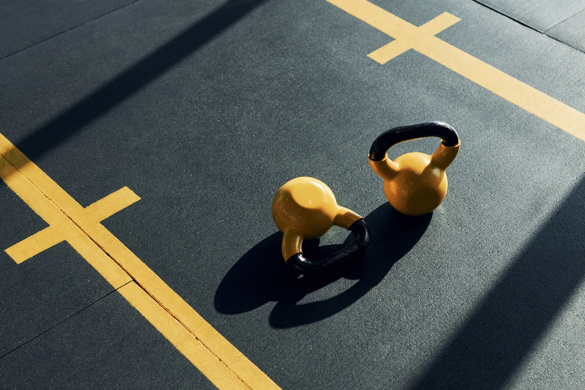 Weights painted in yellow color laying down on the ground in the gym